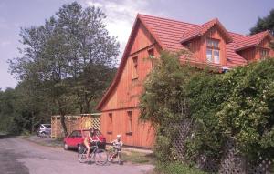 due persone che vanno in bicicletta davanti a una casa di 2 Bedroom Cozy Home In Dautphetal a Amelose