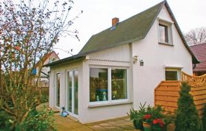 ein kleines weißes Haus mit einem großen Fenster in der Unterkunft Ferienhaus Sundhagen OT Tremt 26 in Falkenhagen