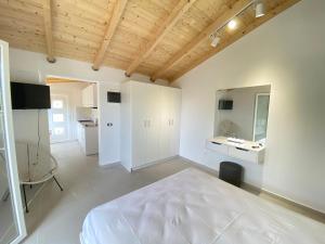 a bedroom with a white bed and a bathroom at Alexander studio in Spartià