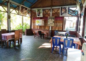 a restaurant with tables and chairs in a room at Tangkoko Ranger Homestay in Bitung
