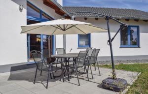 a table and chairs with an umbrella on a patio at Amazing Home In Gerolstein With Kitchen in Gerolstein