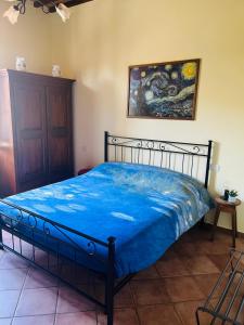 a bedroom with a bed with a blue comforter at La Casina Verde in Siena