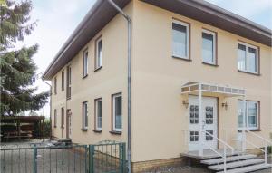 ein Haus mit einer weißen Tür und einem Zaun in der Unterkunft Ferienhaus Am Feldrain R in Stralsund