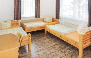 シュトラールズントにあるNice Home In Stralsund With Kitchenの二段ベッド3台、テーブル、椅子が備わる客室です。
