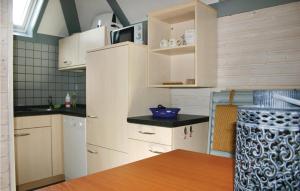 a small kitchen with white cabinets and a table at Ferienhaus 102 In Kirchheim in Kemmerode