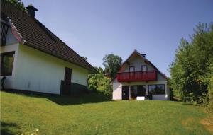 KemmerodeにあるFerienhaus 102 In Kirchheimの庭の隣の赤いバルコニー付きの家