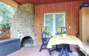 eine Terrasse mit einem Tisch und Stühlen sowie einem Steinkamin in der Unterkunft Ferienhaus Sportplatzweg E in Trieb