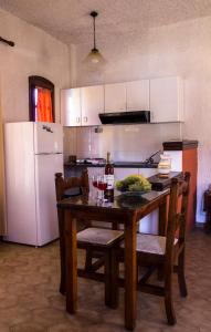 een keuken met een houten tafel en een witte koelkast bij Hesperia Hotel in Karlovasi