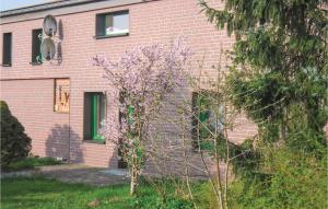 a pink brick building with a tree in front of it at 1 Bedroom Amazing Apartment In Settin in Settin