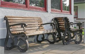 two wooden benches sitting next to a building at Ferienhaus 28 In Kirchheim in Reimboldshausen
