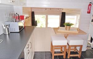 - une cuisine avec un comptoir et des tabourets dans une petite maison dans l'établissement Ferienhaus 101 In Kirchheim, à Kemmerode