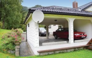 a garage with a car parked in a driveway at Cozy Home In Norheimsund in Norheimsund
