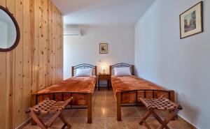 two twin beds in a room with wooden walls at Aphrodite House in Chania