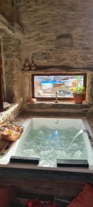una grande vasca da bagno con finestra e lavandino di Casa Rural Therma Agreste a Bermellar
