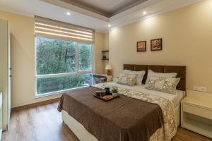a bedroom with a large bed and a window at StayVista at Pristine Pines in Kasauli