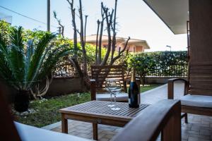 - une bouteille de vin sur une table en bois sur une terrasse dans l'établissement Acquamarina Luxury House, à Aci Castello