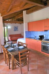 cocina y comedor con mesa de madera y sillas en Appartamenti Ferrari Residence, en Cannobio