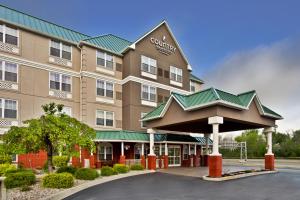 Country Inn & Suites by Radisson, Louisville East, KY في لويزفيل: تقديم فندق بمدخل مسور