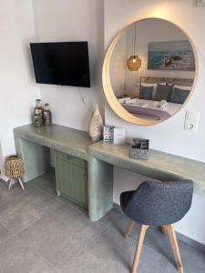 a desk in a room with a mirror and a chair at Xenios Zeus Apartments in Astypalaia