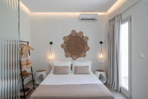 a bedroom with a large white bed with white pillows at Arkasa Palace in Arkasa