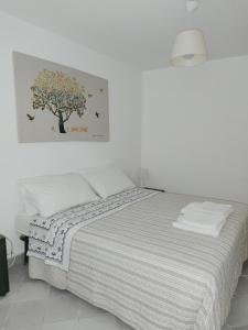 a bedroom with a bed with a tree picture on the wall at Cortile Via Sales 11 in Erice