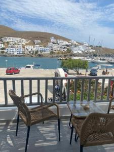 a balcony with chairs and a table and a view of a harbor at Xenios Zeus Apartments in Astypalaia