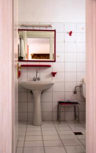 a bathroom with a sink and a mirror and a toilet at Hesperia Hotel in Karlovasi