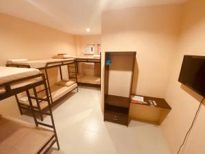 a small room with two bunk beds and a television at Claytown Pension House in Dumaguete