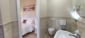 y baño con cama, aseo y lavamanos. en Hotel Residence Piccolo, en Parghelia