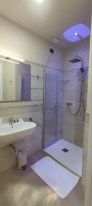 bagno con doccia, lavandino e specchio di Hotel Residence Piccolo a Parghelia