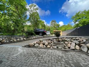 un giardino roccioso con un'auto parcheggiata in un vialetto di Pension Holter Deel a Cuxhaven