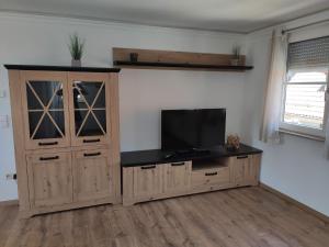 a living room with a tv and a wooden cabinet at Ferienwohnung Barner - KEINE MONTEURE in Owen