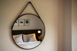 a mirror hanging on a wall with a bed at Flem Mountain Lodge in Flims