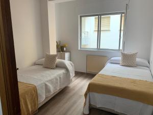 Postel nebo postele na pokoji v ubytování PISO PLAYA SAN CIPRIÁN (MARIÑA LUCENSE)