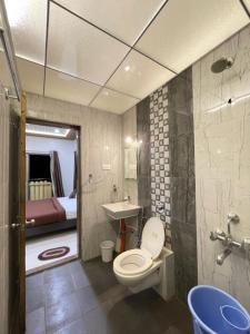 a bathroom with a toilet and a sink and a bed at Dream House Mahabaleshwar in Mahabaleshwar