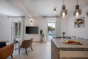 a kitchen and living room with a table and a tv at Villa Mirta in Bol