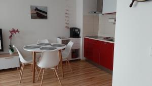 kuchnia ze stołem i krzesłami w pokoju w obiekcie 9 APARTAMENT VILLA NORD - parking w Jastrzębiej Górze