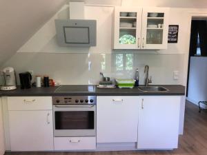 a kitchen with white cabinets and a sink at stay at Randolphs in Kassel