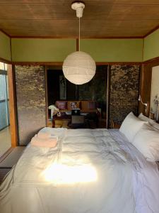 a large white bed in a bedroom with a living room at Hanatsu in Tamano