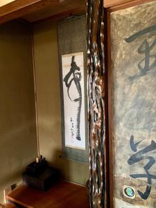 a mirror in the corner of a room with writing on the wall at Hanatsu in Tamano