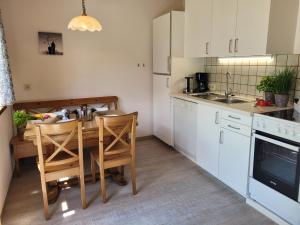 a kitchen with a table and chairs in it at Profelt`s Apartments Uttendorf - Steinbock Lodges in Uttendorf