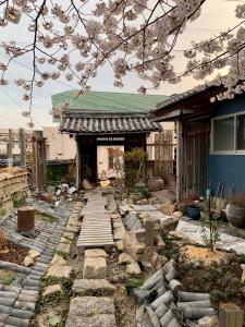 a house with a stone walkway in front of it at Hanatsu in Tamano