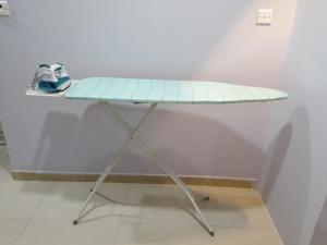 tabla de planchar sobre una mesa en Pharos Inn Sheikh Zaied Private bed space, en Dubái