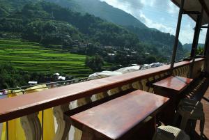 a balcony with benches and a view of a mountain at Banaue Homestay in Banaue