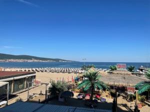 ein Strand mit vielen Sonnenschirmen und dem Meer in der Unterkunft Kaya Apartments in Sonnenstrand + 126 Fotos
