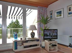a living room with a television and a large window at Ferienwohnung Jepsen in Glücksburg