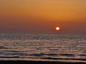 een zonsondergang boven de oceaan met de zon in de lucht bij Barbara in Oletta