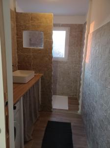 een badkamer met een wastafel en een bakstenen muur bij Barbara in Oletta