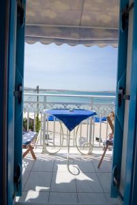 een balkon met een tafel en stoelen en de oceaan bij Studios Naxos in Naxos Chora