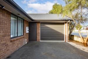 a garage door on a brick house with a driveway at 2 Bedroom house in Hamilton Central in Hamilton